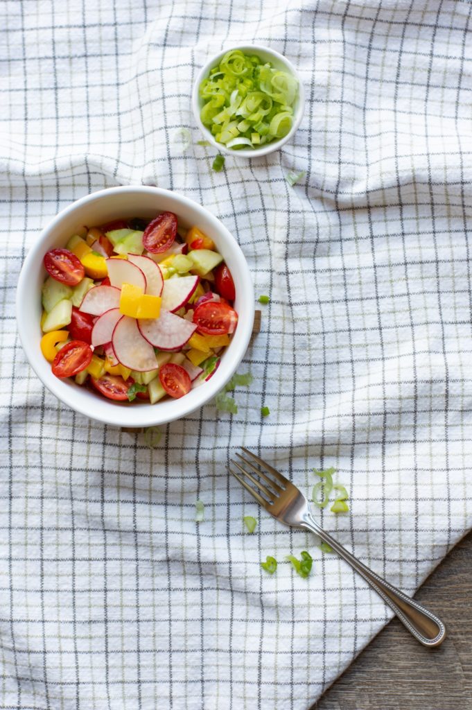chopped rainbow vegetable salad in white bowl