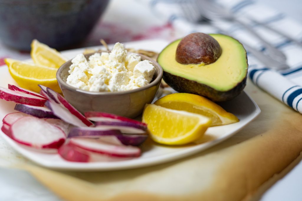 plate with avocado, radish, lemon and feta