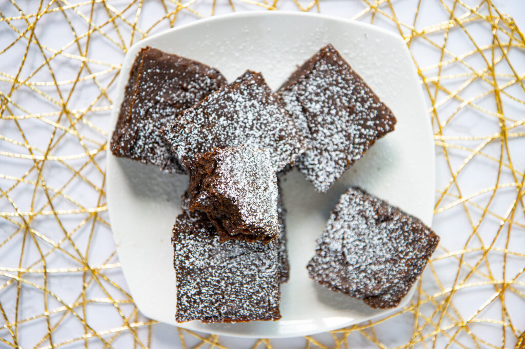 Plate of pumpkin spice brownies with powdered sugar