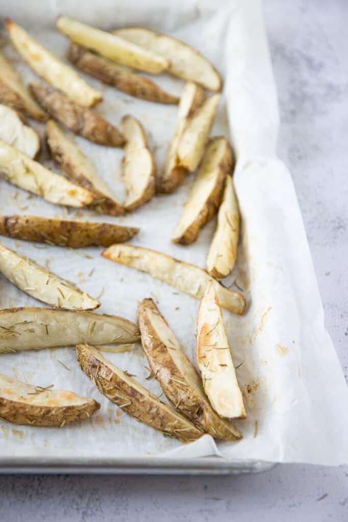 rosemary potato wedges on a baking sheet