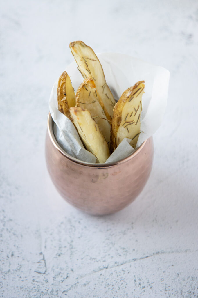 rosemary potato wedges in a copper mug