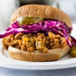 sloppy joe on a bun with pickles and cabbage