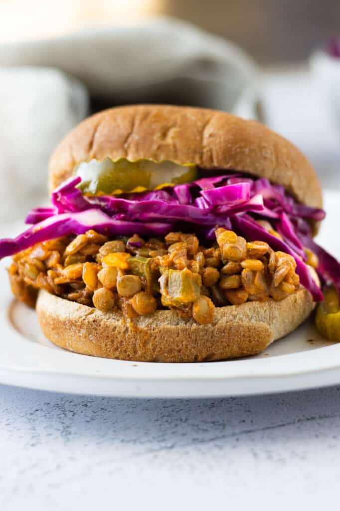 sloppy joe on a bun with pickles and cabbage