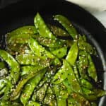maple sriracha snow peas in a cast iron pan