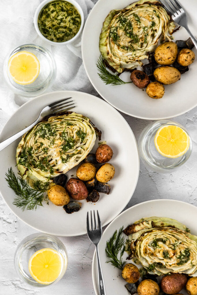 Three bowls of oven roasted cabbage and potatoes with lemon dill dressing.