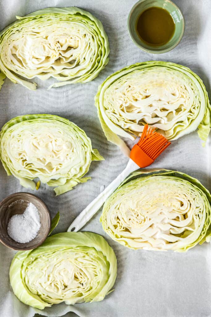 Cabbage rounds on a baking sheet with salt and olive oil.