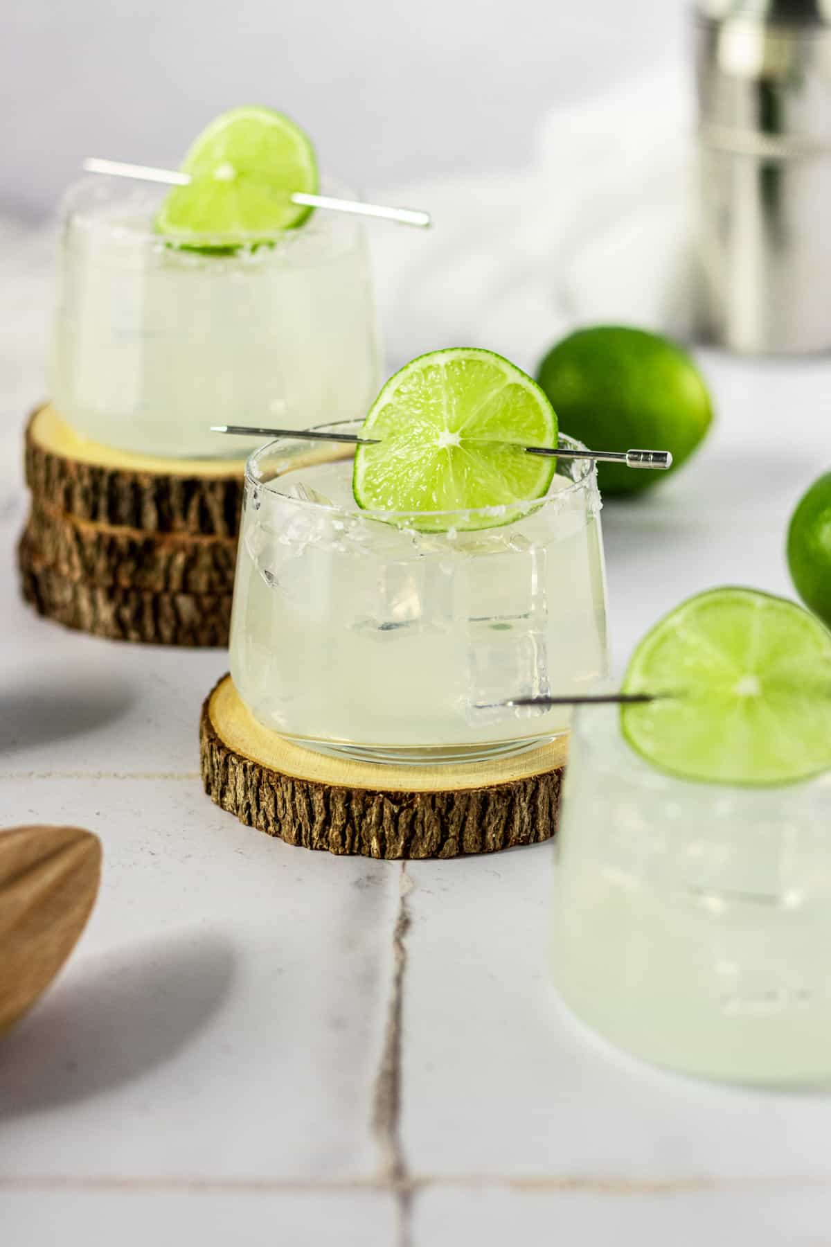 Gin margaritas in three glasses garnished with a lime wheel.