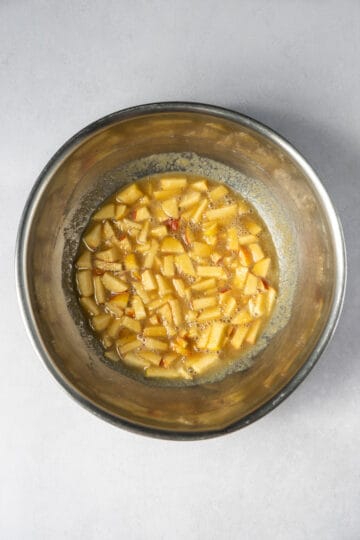 Large mixing bowl with chopped apples, applesauce and brown sugar.