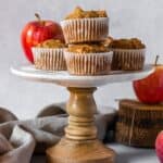 Stack of muffins with apples on a cake stand.