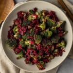 Broccoli beetroot salad in a large white bowl on a linen cloth.