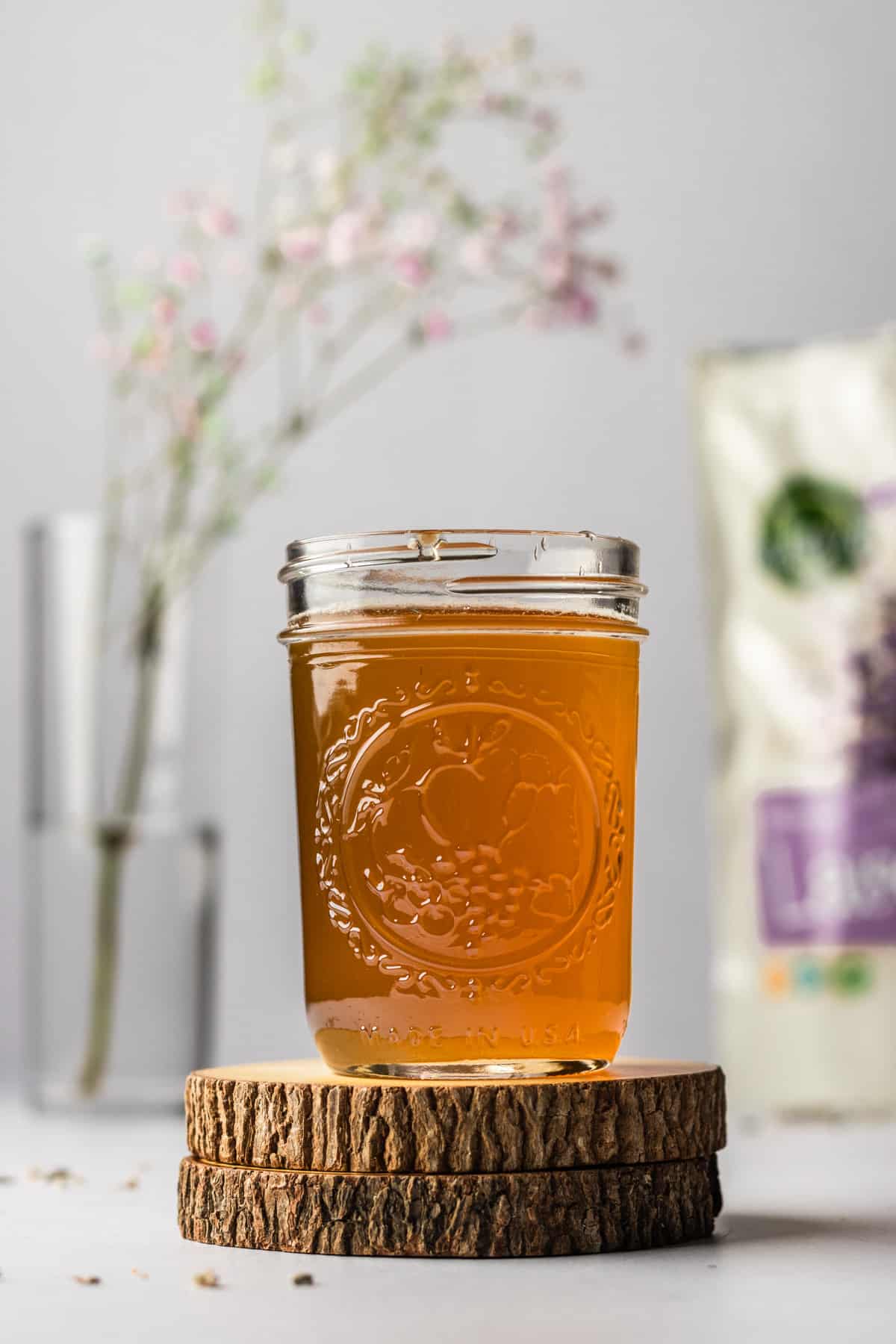 Small mason jar on wooden coasters filled with honey lavender simple syrup.