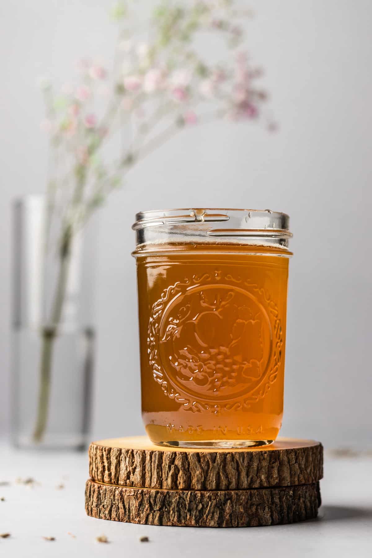 Small mason jar on wooden coasters filled with honey lavender simple syrup.