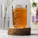 Small mason jar on wooden coasters filled with honey lavender simple syrup.