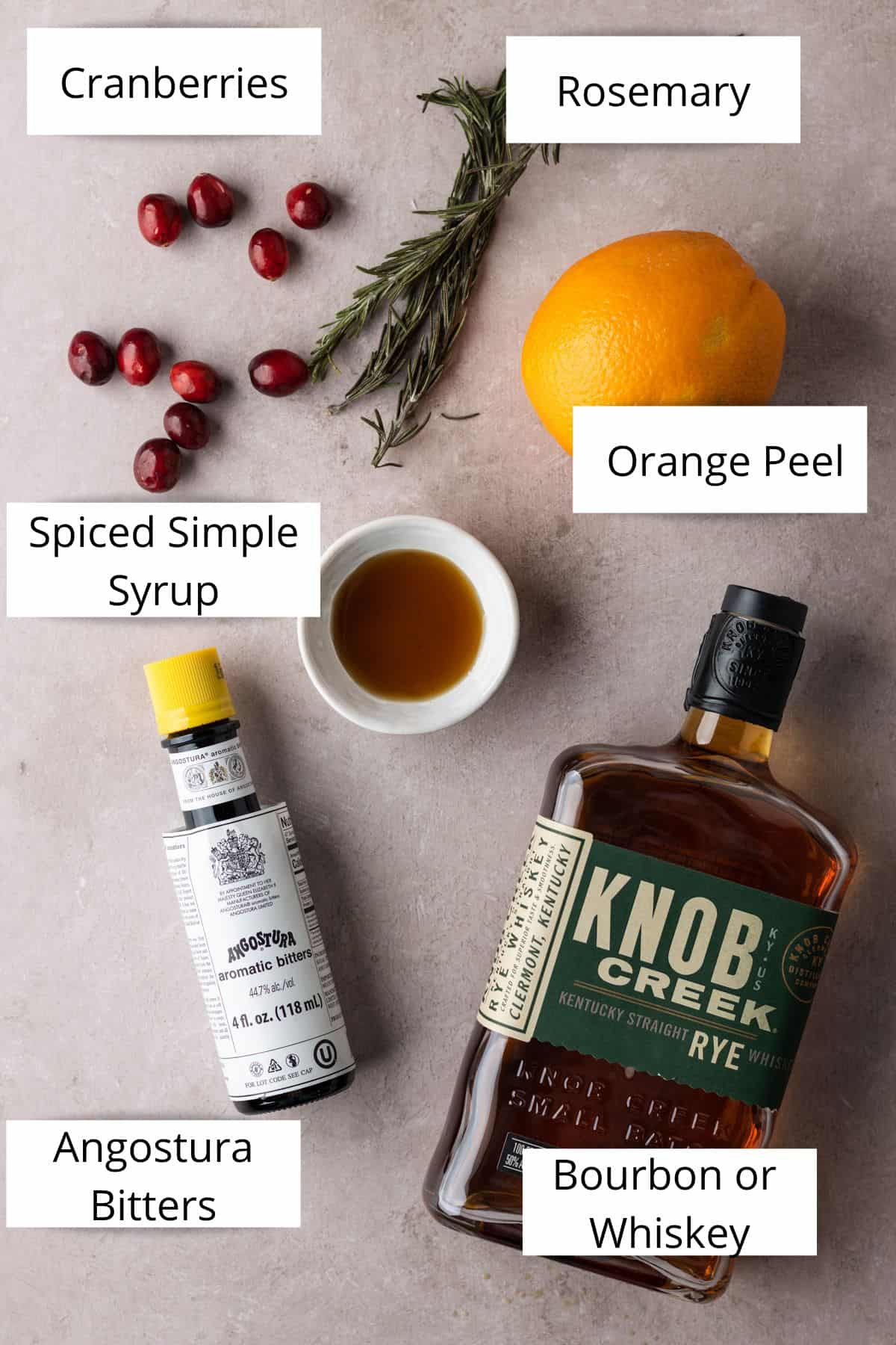 Cranberries, rosemary springs, an orange, a small bowl of simple syrup, knob creek whiskey, and angostura bitters.