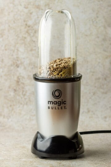 Magic Bullet blender filled with sunflower seeds, nutritional yeast and salt before being blended.