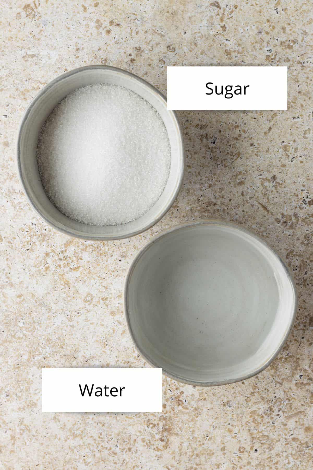 Overhead view of a bowl of cane sugar and another bowl of water.