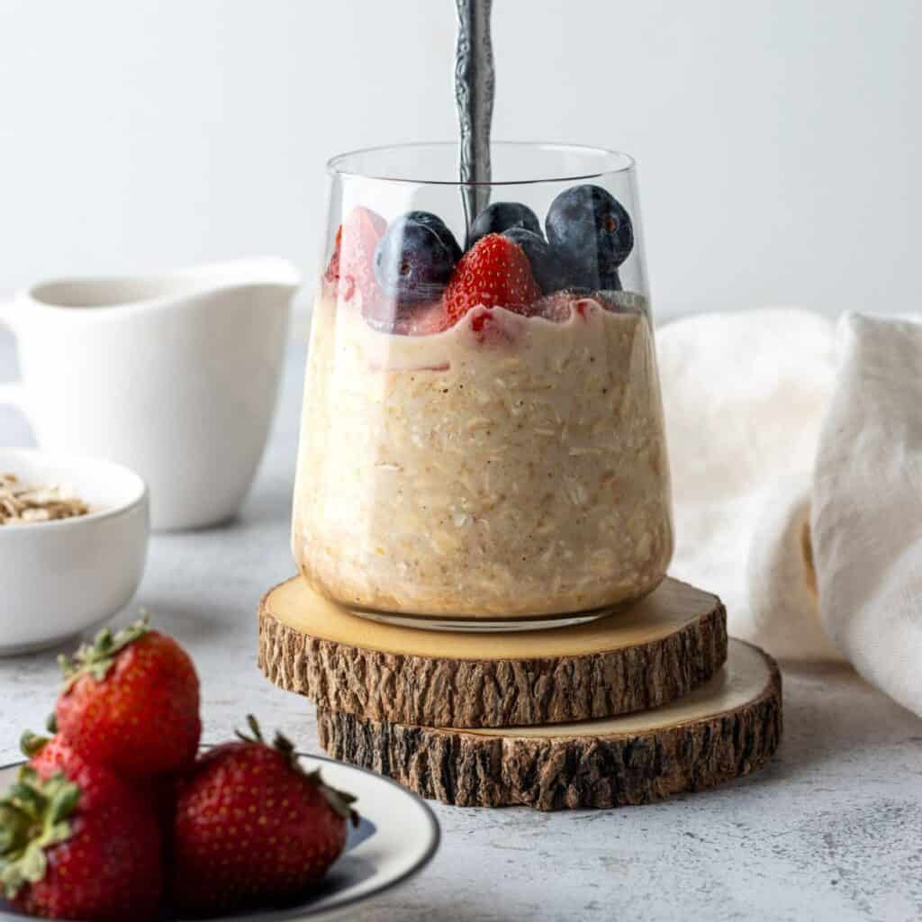 A jar of PB&J overnight oats with fresh berries.
