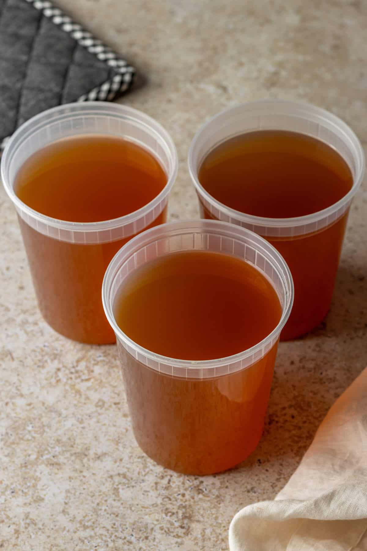 Three quart-sized containers with vegetable broth.