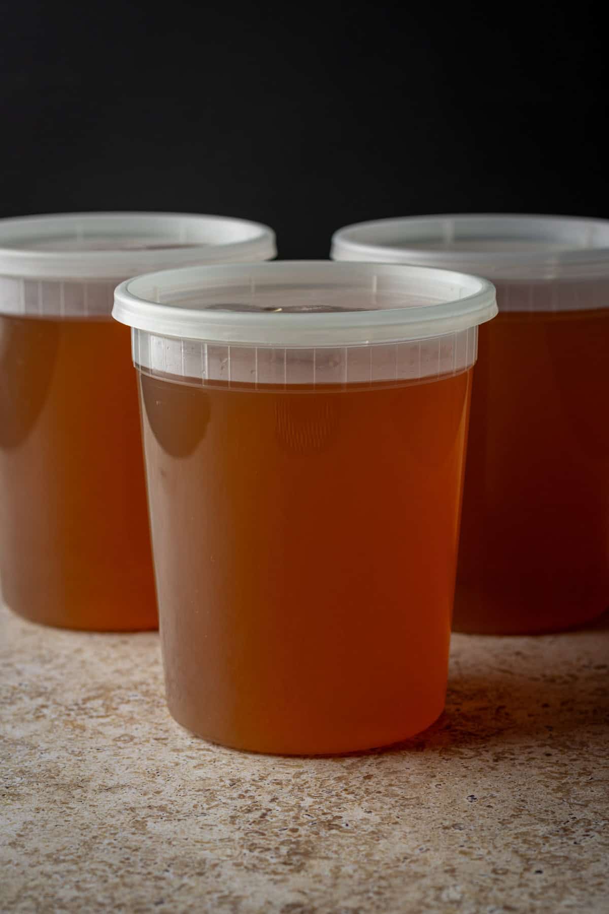 Three quart-sized containers with vegetable broth.