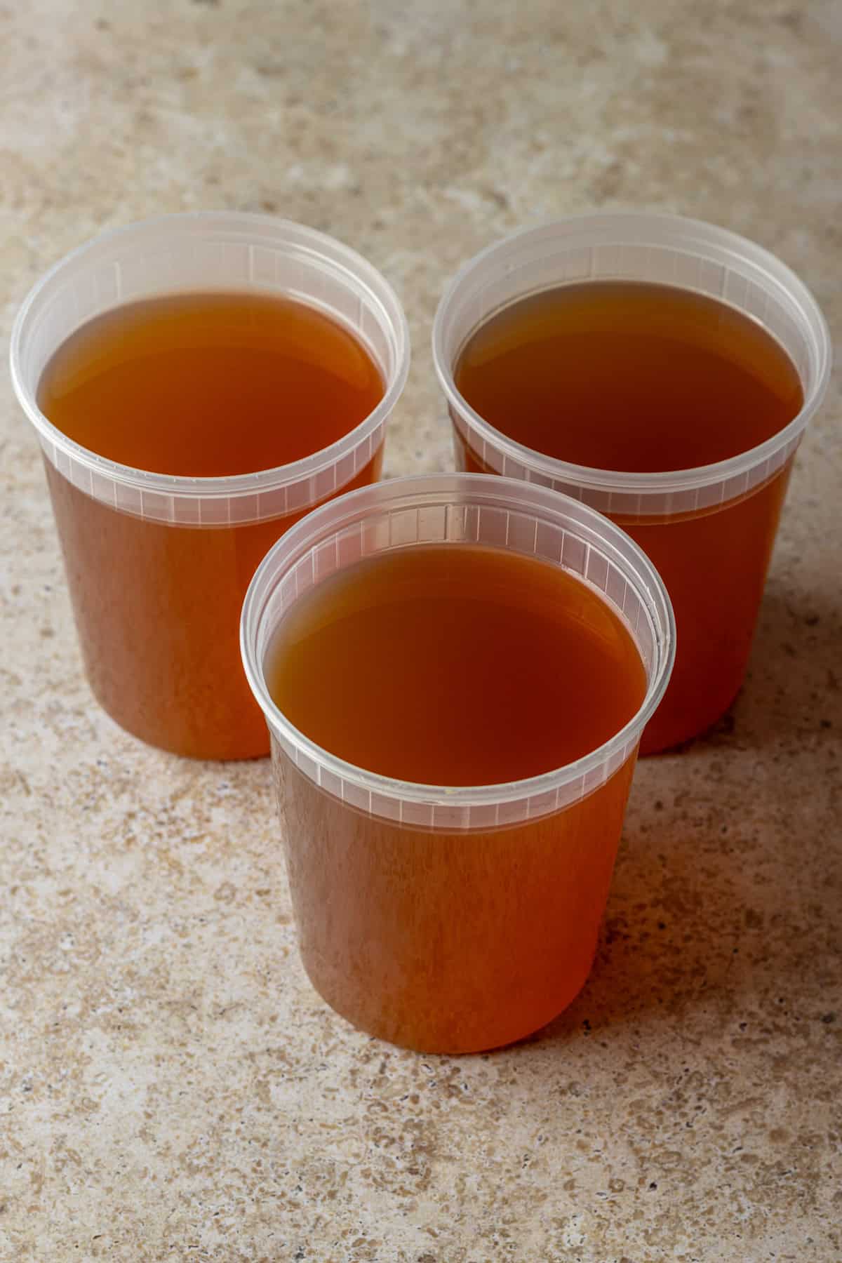 Three quart-sized containers with vegetable broth.