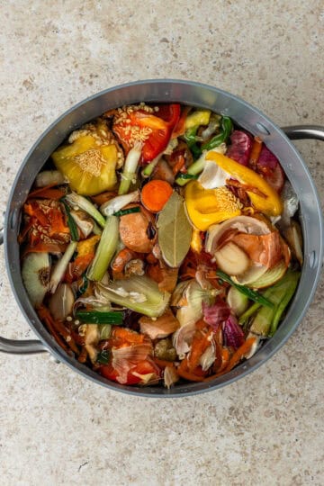 A large pot of vegetable scraps in water.