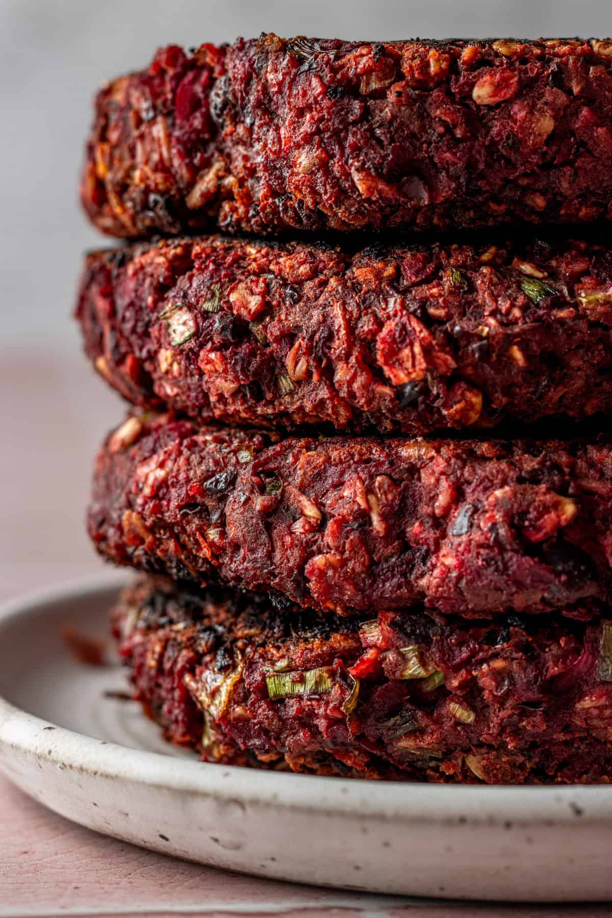 A stack of black bean beet burgers on a plate.