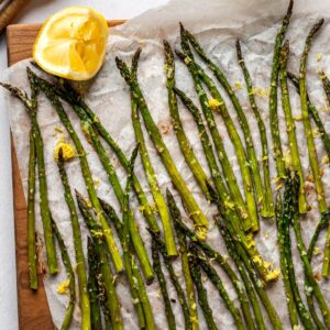 Close up of roasted asparagus with a lemon wedge.