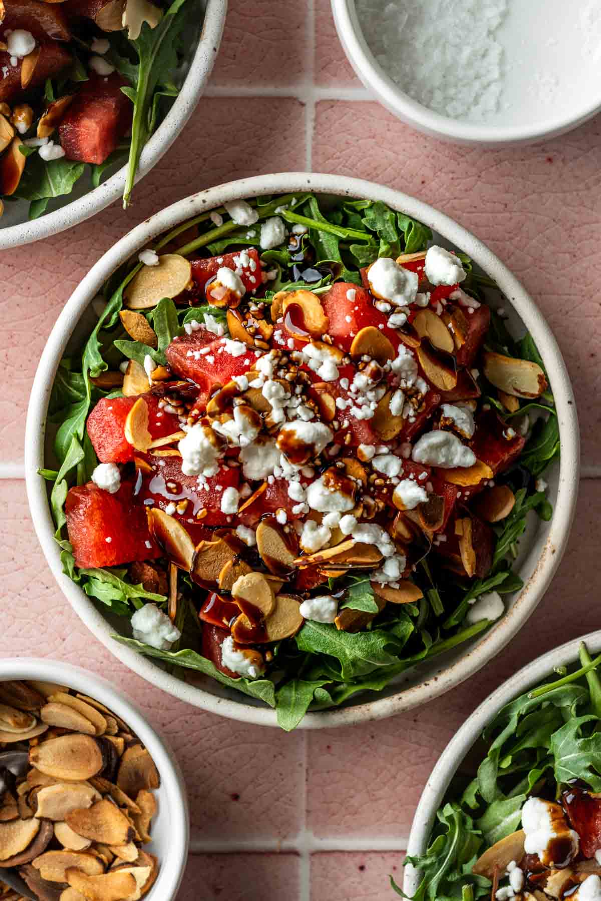Watermelon arugula and goat cheese salad in a white bowl.