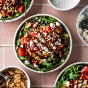 Close up of a bowl of arugula watermelon goat cheese salad.