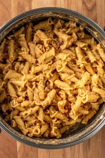 A large pot with campanelle pasta tossed in sauce.