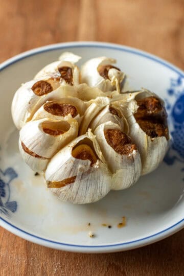 A head of roasted garlic in a bowl.