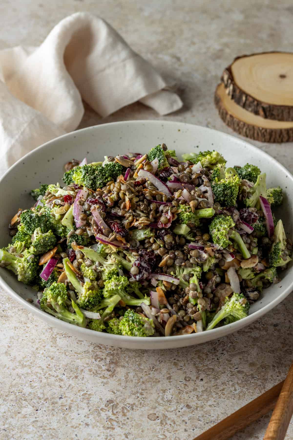 A bowl of broccoli lentil salad with red onions.