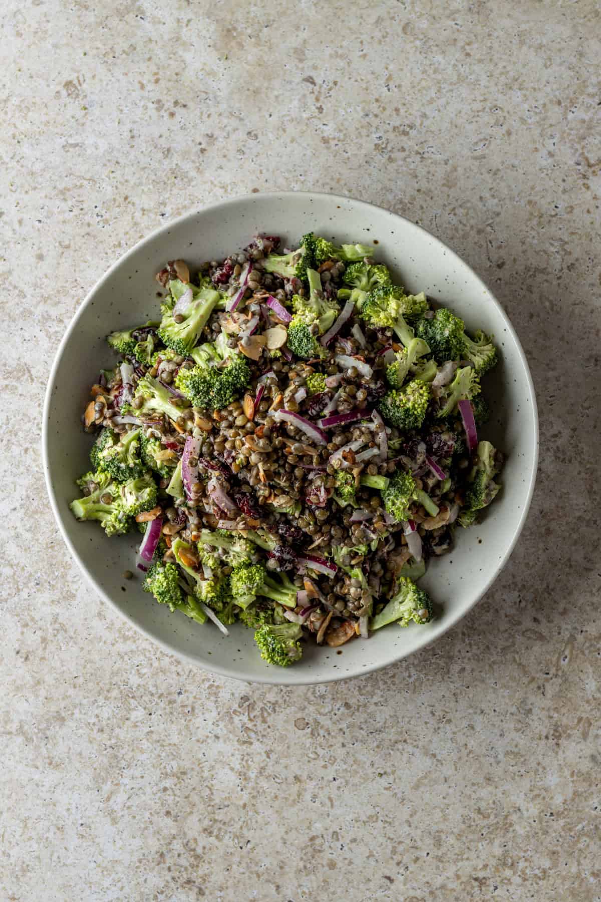 A white bowl of broccoli lentil salad.