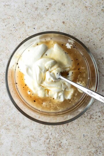Greek yogurt dressing being mixed together in a bowl.