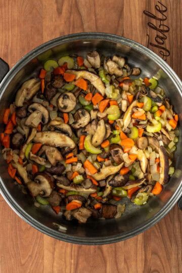 A pot of sautéed mushrooms and vegetables.