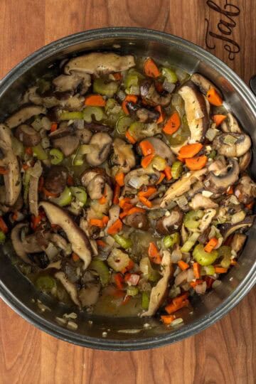 Sautéed onions, carrots, celery and mushrooms in a large pot.