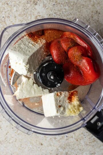 Feta and roasted red peppers in a food processor.