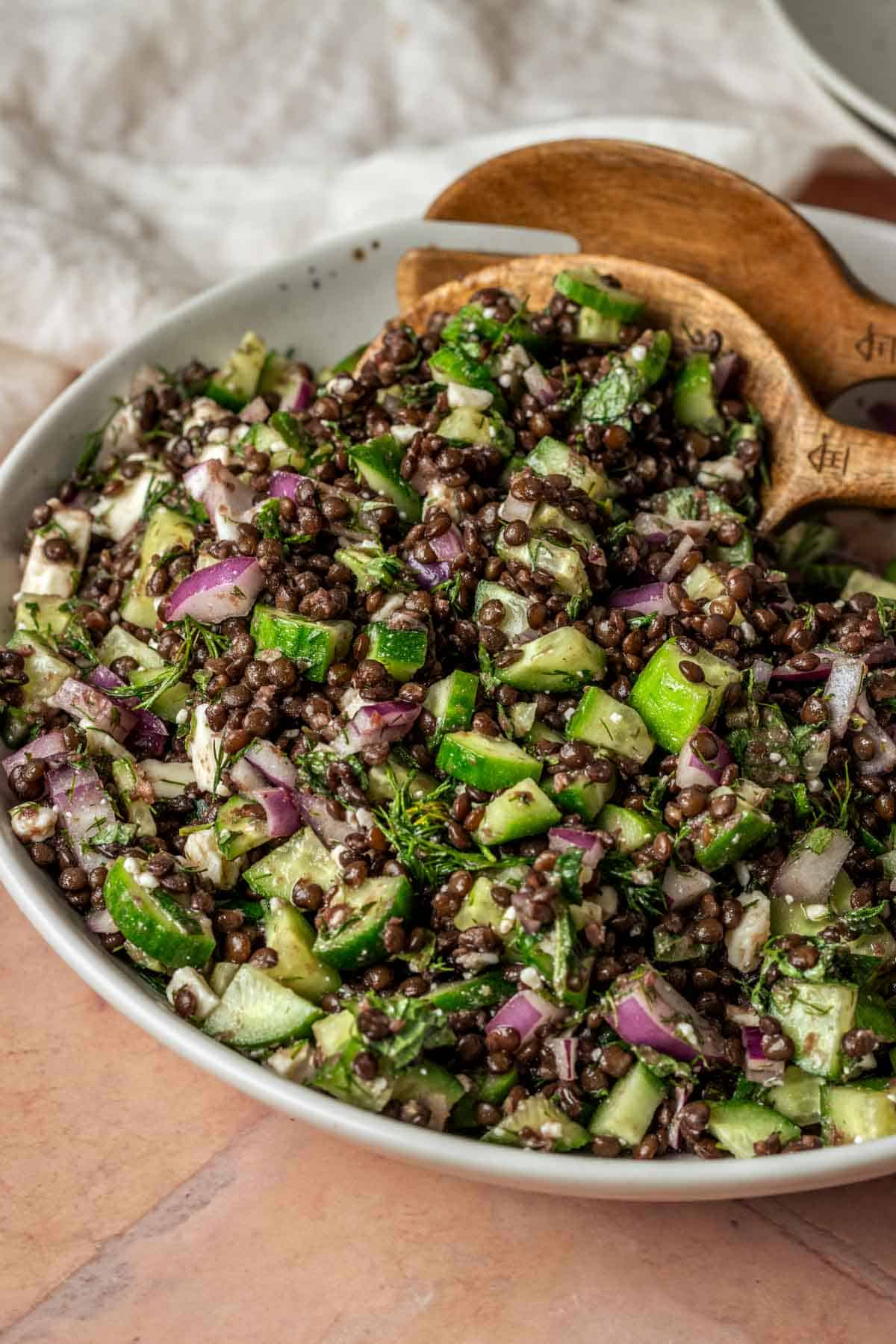 A bowl of black lentil salad with fresh herbs.