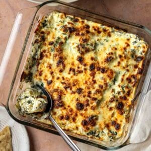 Baked greek yogurt spinach and artichoke dip in a baking dish.