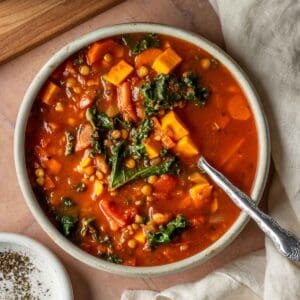 Lentil vegetable soup with kale in a bowl with a spoon.