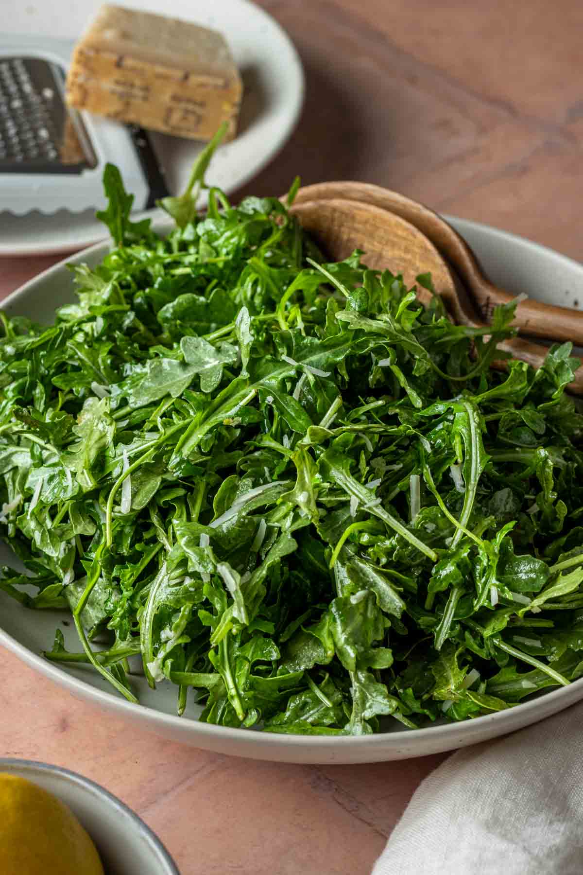 A bowl of arugula salad with parmesan cheese.