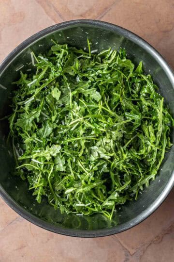 Arugula salad in a large mixing bowl.