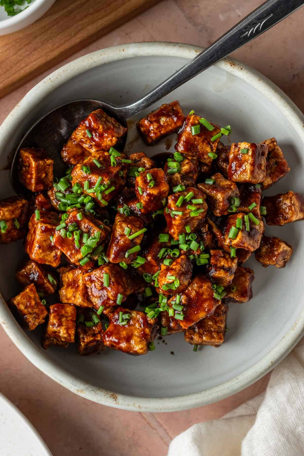 A bowl of barbecue tofu topped with chives.