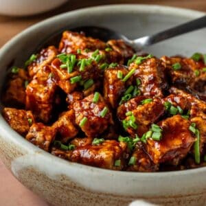BBQ tofu in a bowl garnished with chives.