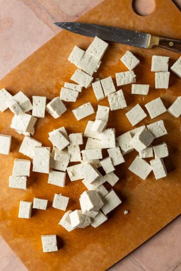 Cubed tofu on a cutting board.