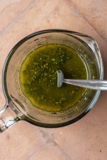 Dill mustard dressing in a glass measuring cup.