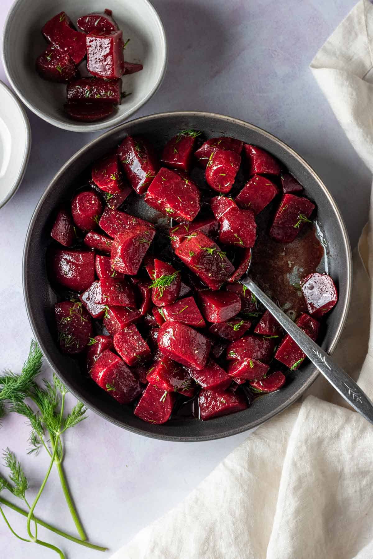 Pickled beet salad in a bowl with a spoon.